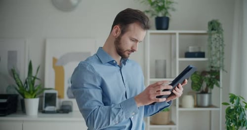 Young Adult Using Tablet With Stylus Indoors