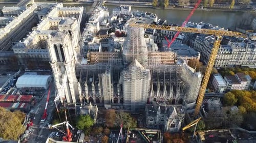 Drone with movement backwards away from the Notre Dame church in Paris during renovation, many crane