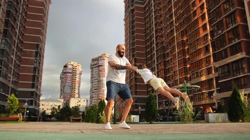 Dad and Daughter Playing in Urban Playground