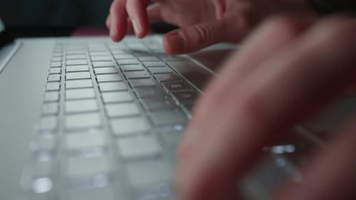 Hände, die nachts auf der Laptop-Tastatur tippen