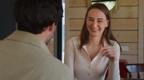 Woman Laughing and Talking to Man Indoors
