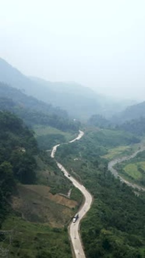 Route qui traverse la vallée près de la rivière entre les montagnes et les arbres au Vietnam