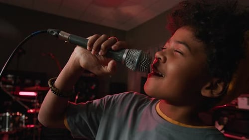 Close-up of Teenage Musician Singing into Microphone with Eyes Closed