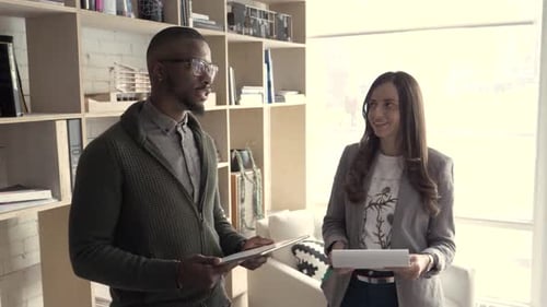 Two Colleagues Discussing Work in Office Adult