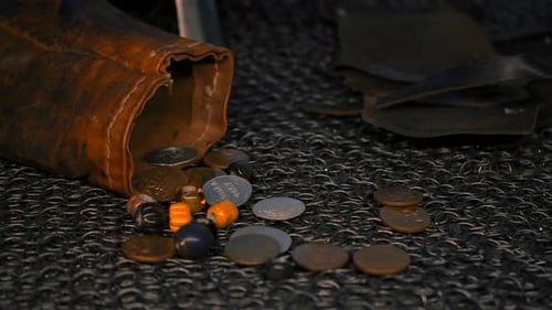 Old Slavonic things. Media. A black carpet with a leather glove and coins lying on the table.