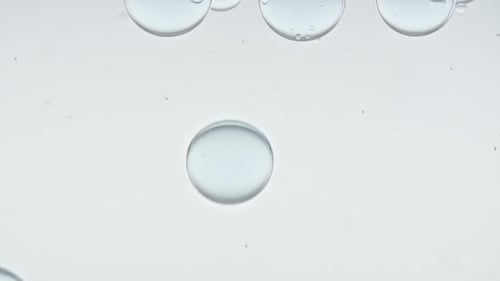 Foto macro de bolhas de ar transparente de tamanhos diferentes em água limpa subindo sobre o corpo de fundo branco