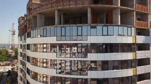 Luftbild des Betonrahmens eines im Bau befindlichen hohen Glaswohnhauses in einer Stadt