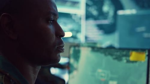 Focused Man Working at Computer Terminal at Night