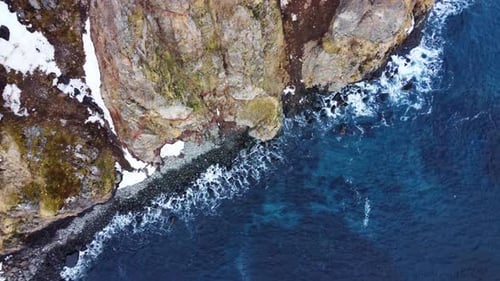 Flying Over Rocky Coastline Alongside Cliffside with Blue North Atlantic Ocean Water at Spring