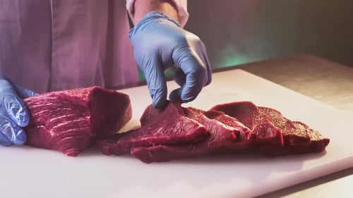 A Man Cook Cuts a Fresh Red Raw Fillet in a Butcher's Shop with a Kitchen Knife Slices Premium
