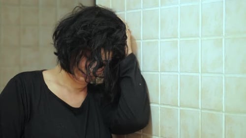 Woman Leaning Against the Wall in Distress