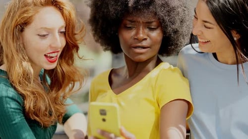 Happy Friends Looking at Phone and Laughing