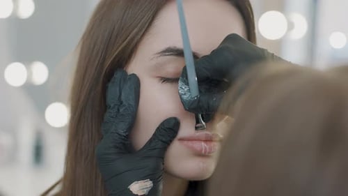 Cosmetology practice with a girl getting makeup applied in a salon setting during the afternoon hour