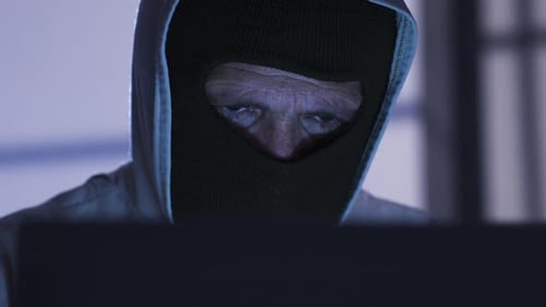 Ein
männlicher Hacker begeht ein Verbrechen, indem er ein Passwort vom Laptop knackt. Illegal.