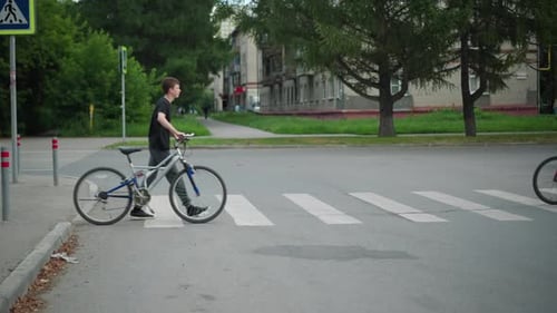 Pessoa andando de bicicleta pela faixa de pedestres urbana com o carro que se aproxima