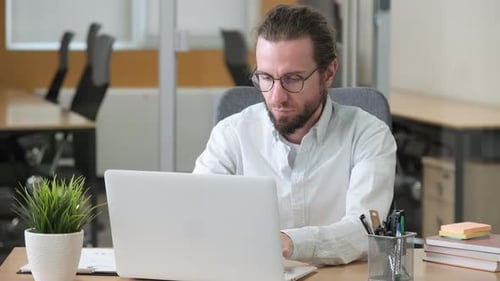 Man Working on Laptop at Office Desk