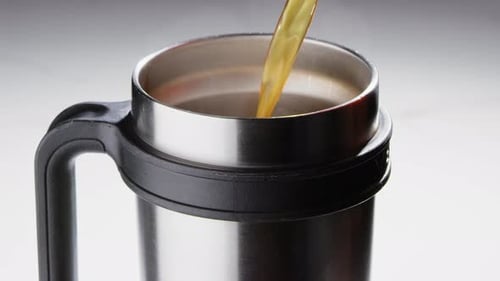 Pouring Coffee or Tea into Stainless Steel Mug