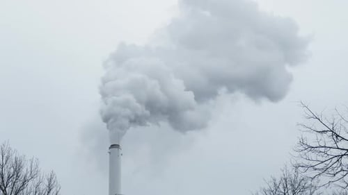 Smoke Swirling From Chimney of Building Fouling the Sky