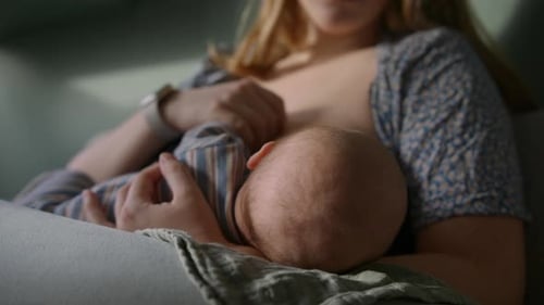 Madre amamantando al bebé en casa
