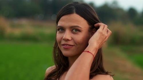Smiling Young Woman Poses in a Green Field