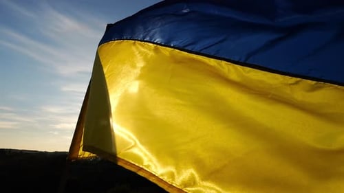 Ukrainian Flag Waving in the Wind at Sunset