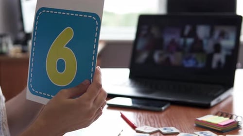 An elementary school teacher teaches a lesson online via a webcam in the classroom.