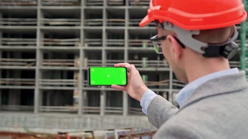 Construction Inspector Checking New Building Parameters with Smartphone App