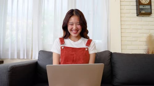 Woman Cheering While Using Laptop at Home