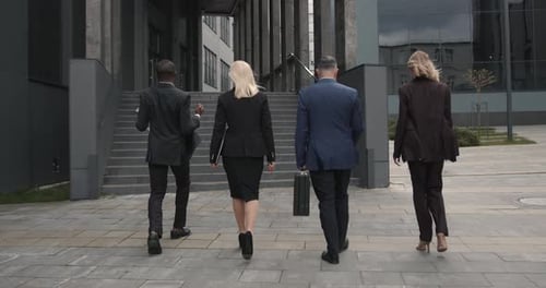 Business People Walking Outdoors Near Office Building