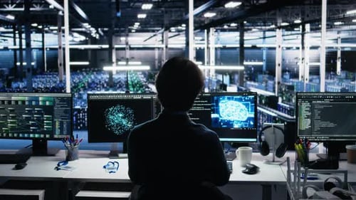 Person at Computer with Multiple Screens in Office