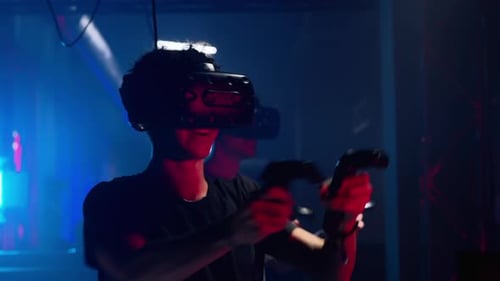 Group of people playing VR games in a studio with blue pink neon lights