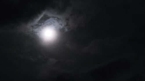 Vollmond am Nachthimmel bewegt sich durch dunkle Wolken Zeitraffer