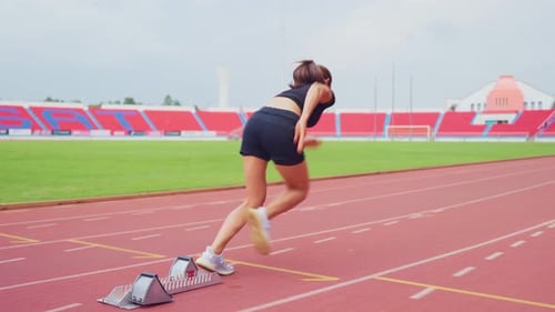 Asian young sportswoman sprint on a running track outdoors on stadium.