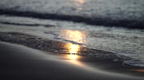 Peaceful ocean waves reflecting golden sunlight during serene sunset moment