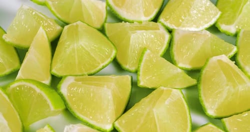 Ripe Lime Fruits with Slices and Lime Halves Slowly Rotating on a White Background. Macro Video