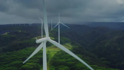 Wind Turbines Spinning Among Green Rolling Hills