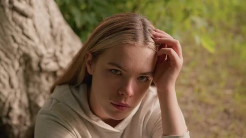 Young Adult Contemplating Nature by a Tree