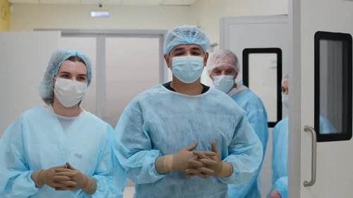Medical Staff in Scrubs Walking through Hospital Hallway