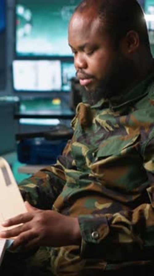 Man in Camouflage Uniform Reading Documents