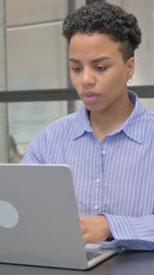 Young Woman Coughing While Working on Laptop