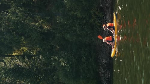 People floating on inflatable boat along calm tranquil river. Vertical video