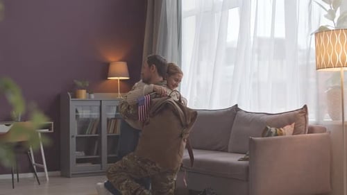 Soldier's Emotional Homecoming Hugs Child with American Flag