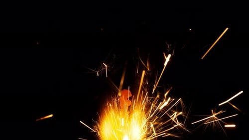 Bright Sparkler Emitting Golden Sparks on Black Background