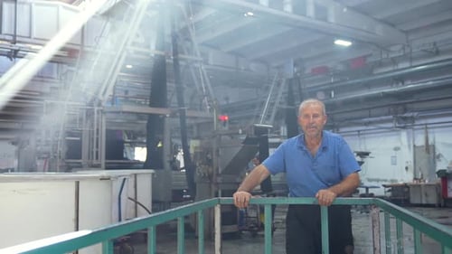 Factory Worker in Textile Mill Inspects Equipment