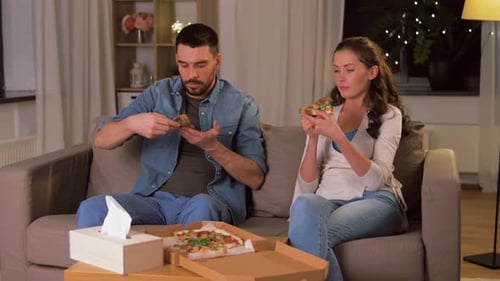 Couple Enjoying Pizza Together in Living Room