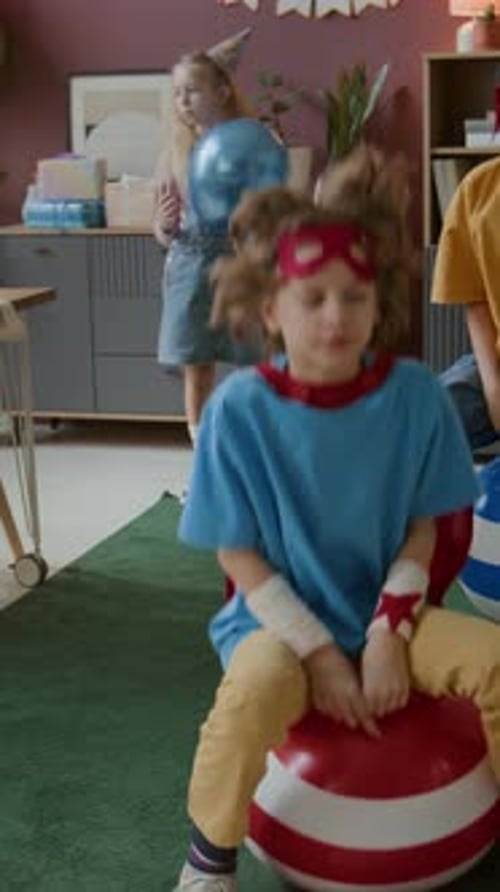 Children Bouncing on Balls at Party Indoors