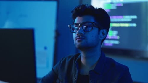 Un programmeur masculin sérieux corrige des erreurs dans le code informatique.