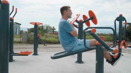 Active Man Exercising at Outdoor Gym Young Male Doing Abdominal Muscle Exercises on Street