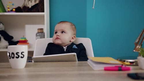 Adorable Cute Baby Dressed in Professional Business Attire at an Office Desk with a Tablet