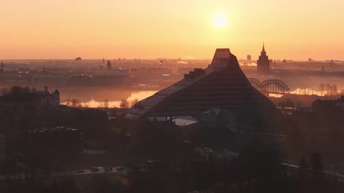 Sonnenaufgang am Morgen über Riga mit Nationalbibliothek und nebligem Stadtbild